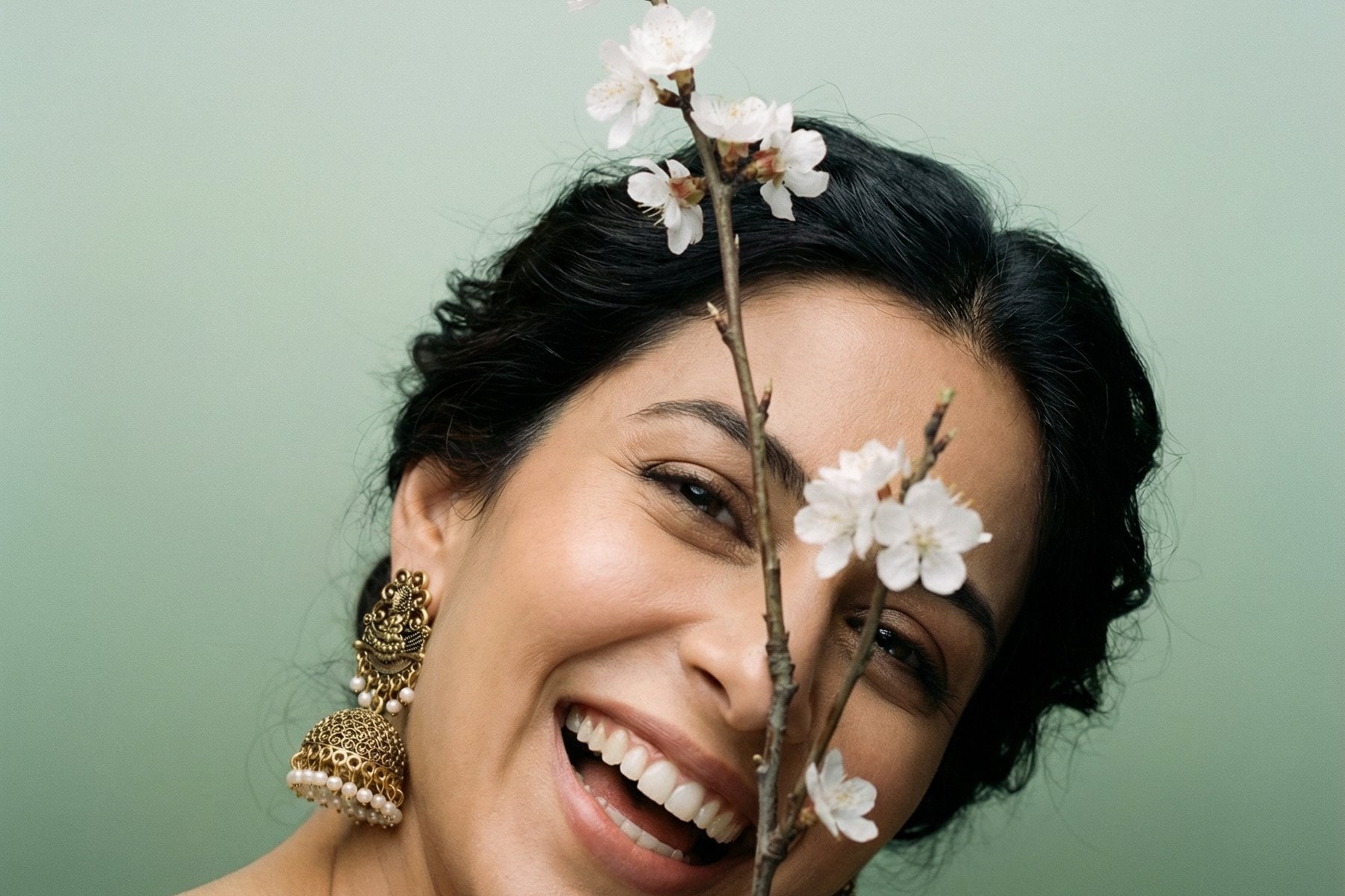 Jhumka Ohrringe goldfarben — lachende Frau mit Blütenzweig, Raja Rani Boutique